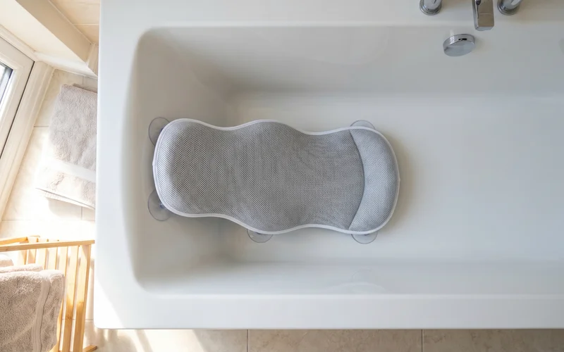 Angelcare baby bath support fitted inside a standard UK family bath tub showing the non-slip suction feet