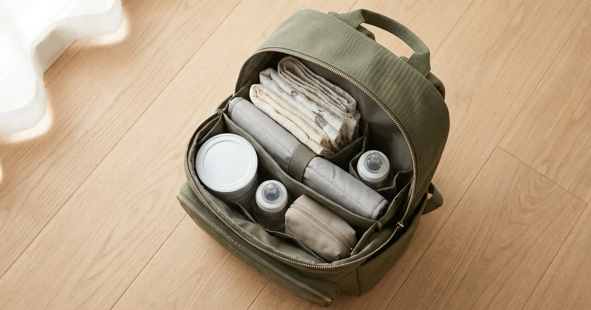 Best baby changing bags UK 2026 — stylish backpack flat lay with organised nappy compartments