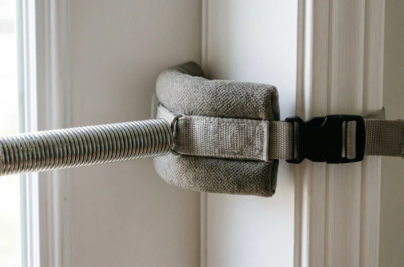 Baby door bouncer fitting UK — clamp attached to wooden door frame with spring and seat correctly positioned