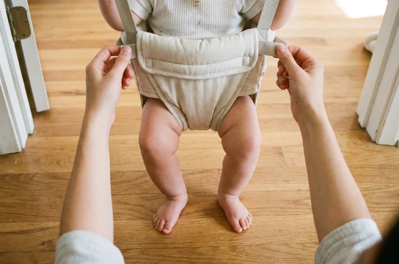 Baby door bouncer overhead view UK 2026 — baby in padded seat with spring attachment