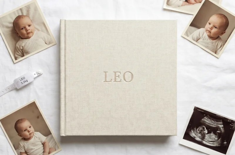 Personalised baby photo album UK — linen cover with embossed baby name, printed photos and scan photo flat lay