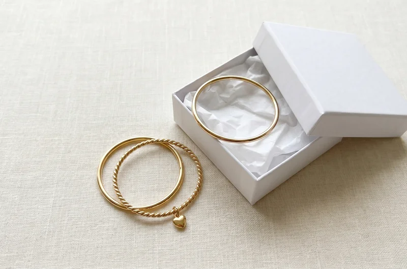 Baby's gold bangle styles UK — plain, twisted rope and heart charm in 9ct yellow gold